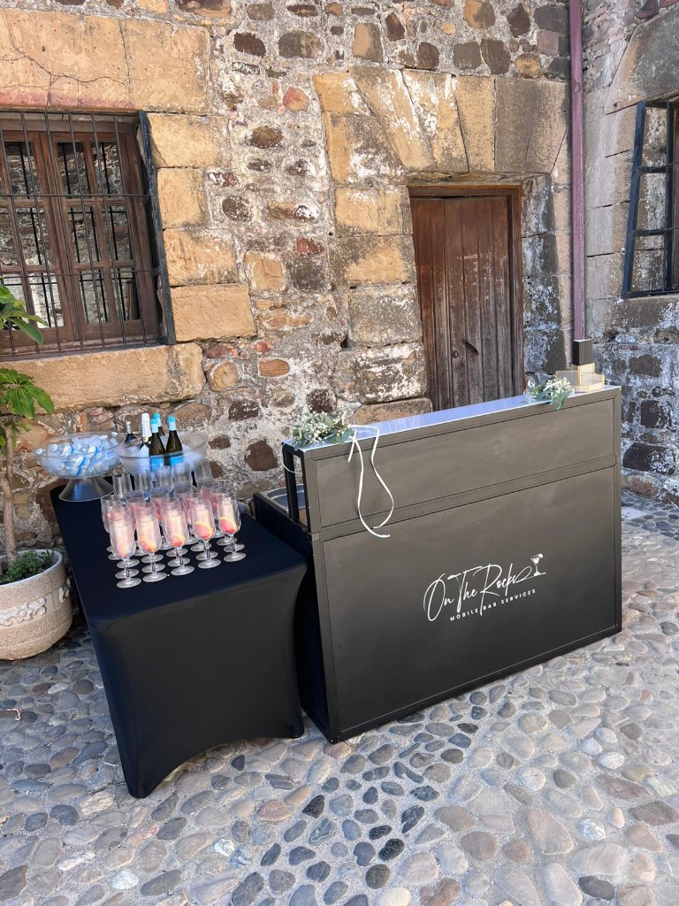 Black mobile bar with champagne flutes and wine bottles