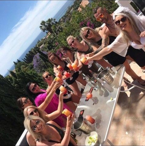 Hen party group raising cocktails on a sunny terrace