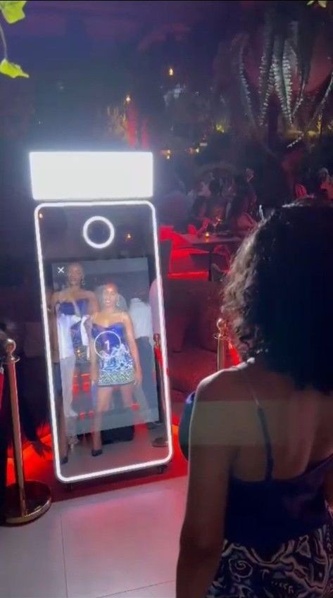 Guest using a mirror photo booth at an evening event