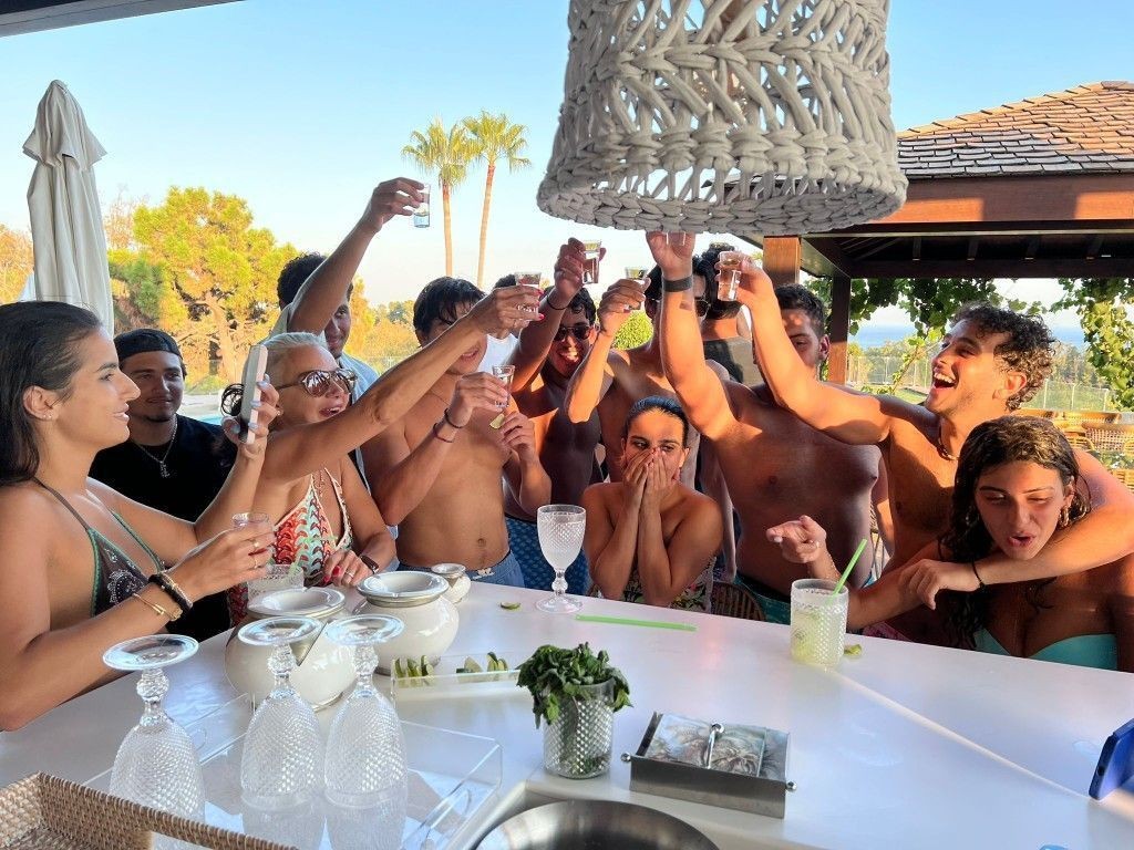 Pool party with cocktail shots being served at a villa