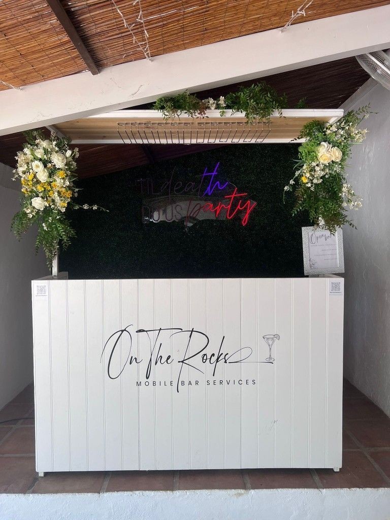 Neon-lit wedding bar setup at an evening celebration